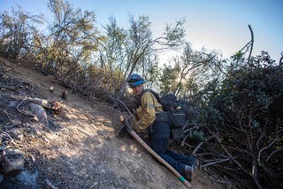 Firefighters work to create a containment fire line to control the Hughes Fire in Castaic, California, on Wednesday. Firefighters have stopped the fire’s forward progress